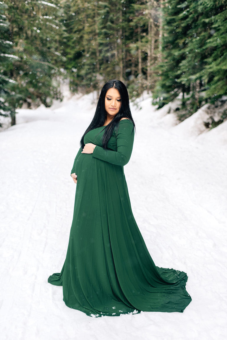 Girl in green dress during snowy maternity session
